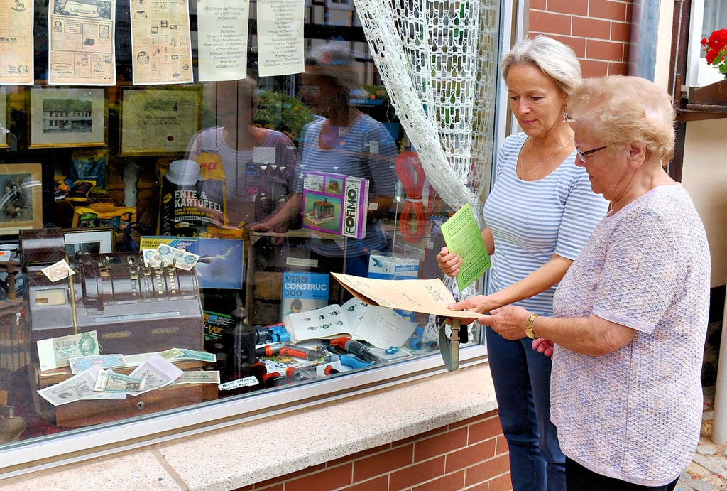 Kathrin (links) und Gerda Goyer schauten sich vor dem Stammsitz des Arendseer Unternehmens an der Friedensstraße alte Schiftstücke an.