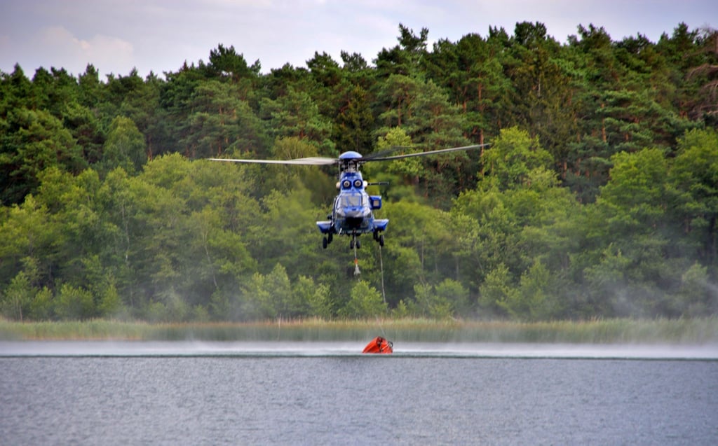 Ein Hubschrauber tankt Löschwasser zur Bekaämpfung des Waldbrands auf dem ehemaligen Truppenübungsplatz.