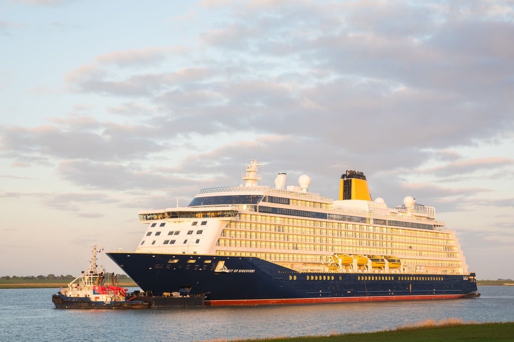 Ein Kreuzfahrtschiff fährt am frühen Morgen über die Ems.