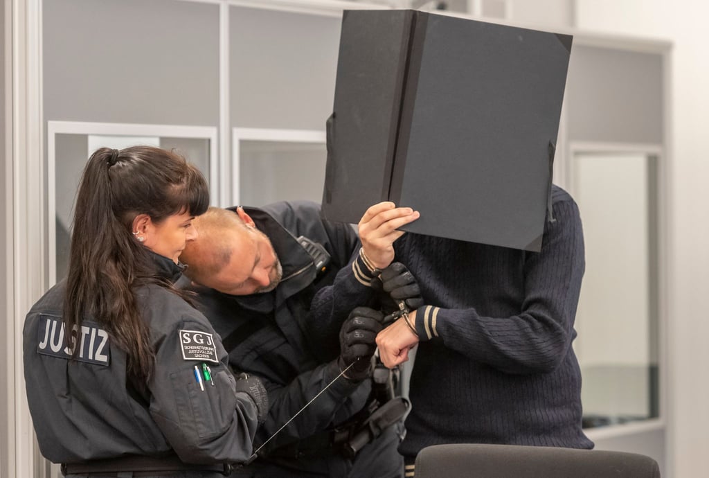 Ein Angeklagter (r) im Prozess um den Juwelenraub im Grünen Gewölbe wird bei der Fortsetzung des Prozess in den Verhandlungssaal im Landgericht geführt.
