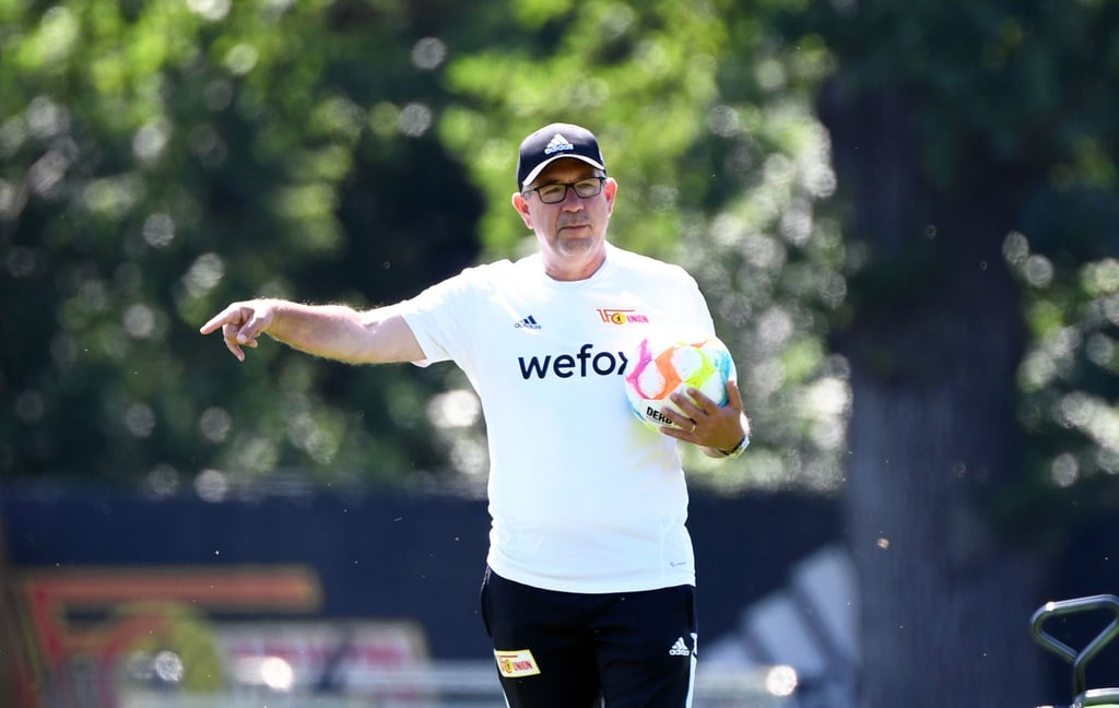 Trainer Urs Fischer kommt mit Ball auf den Trainingsplatz.