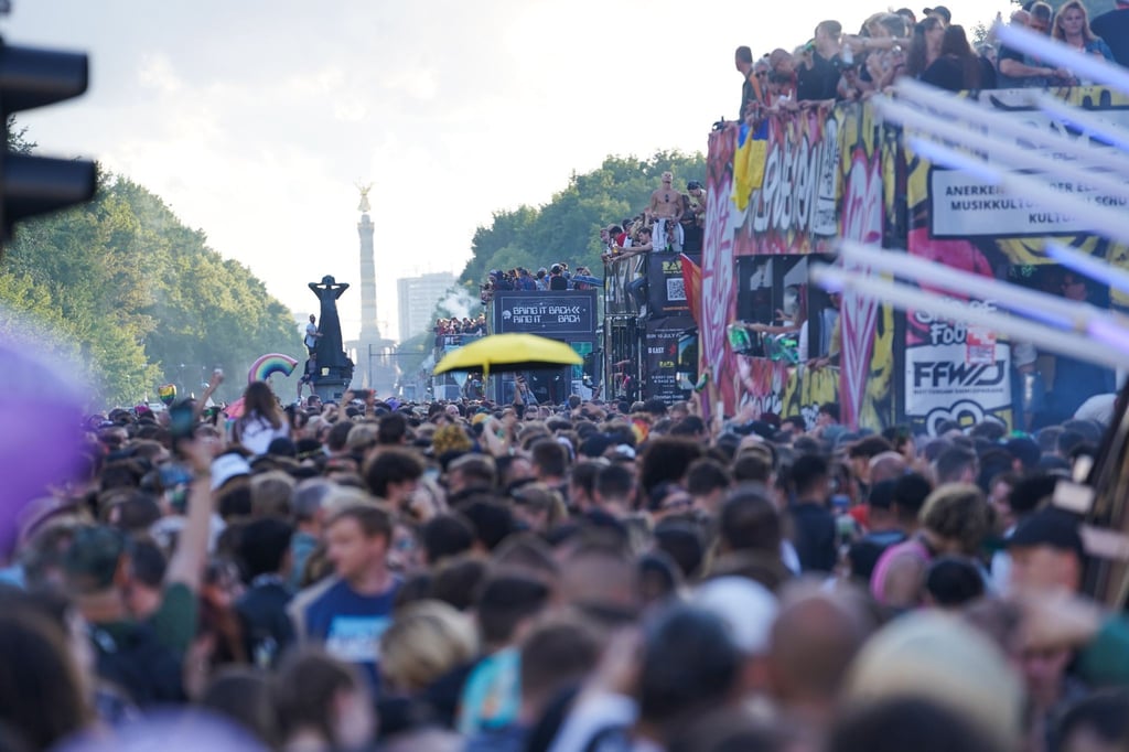Eine Parade aus Technofans zieht tanzend auf der Straße des 17. Juni vorbei.