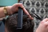 Ein Friseurin schneidet die Haare eines Kunden. Dass Frauen meist deutlich mehr beim Friseur zahlen müssen als Männer, will der Stuttgarter FDP-Nachwuchs per Gesetz verbieten lassen.