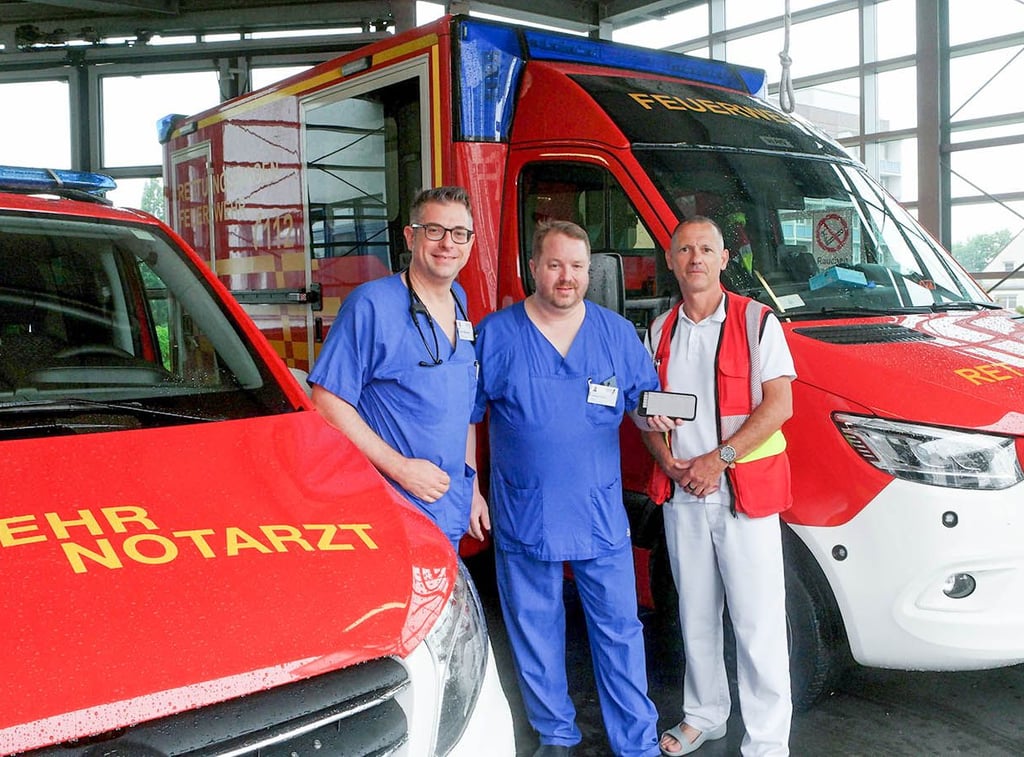 Jakob Silbernagl, Oberarzt Klinik für Innere Medizin II, Georg Fürnau, Chefarzt der Klinik für Innere II, und Jörg Petersohn, Ärztlicher Leiter des Rettungsdienstes der Stadt, vor den frisch aufgerüsteten Notarzt- und Rettungswagen.