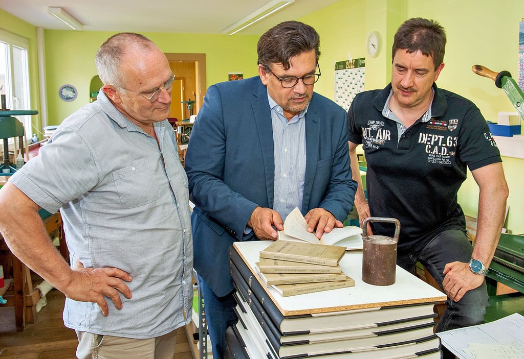 NDZ-Leiter Ralf Eichberg (v.l.) schaut sich mit OB Armin Müller (vor dessen Corona-Erkrankung) an, wie gut Drucker Heinz-Peter Felber die Repliken der armenischen „Zarathustra“-Übersetzung hinbekommen hat.