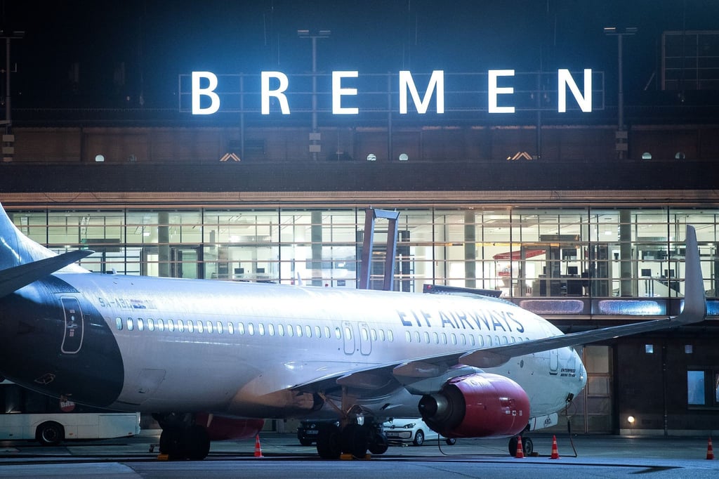 Ein Flugzeug steht nachts auf dem Rollfeld vom Flughafen Bremen.