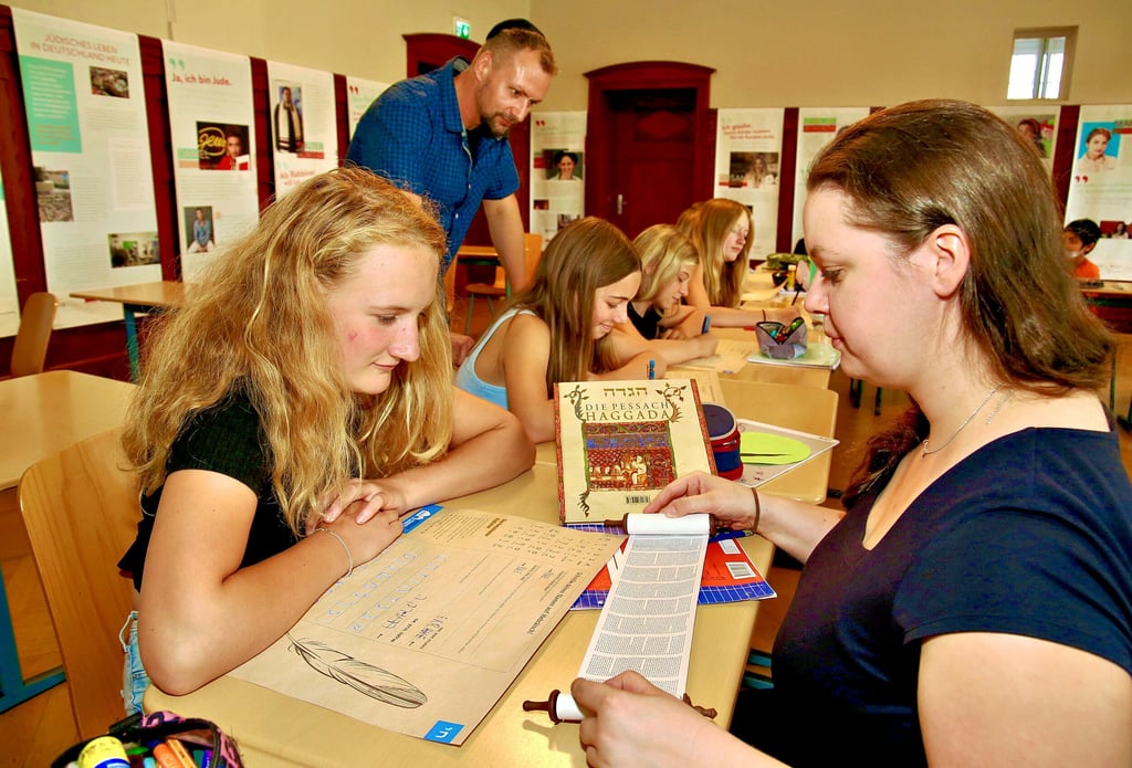 Anett Gottschalk (re.) und Sven Wabersitzky (hi. li.) erklären Schülern des Gymnasiums Carolinum in Bernburg jüdische Feiertage wie Pessach.