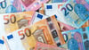 Illustration: Euro-Banknoten auf einem Tisch: Die Zahl der Menschen in Sachsen-Anhalt, die Einkommen von mehr als einer Million Euro im Jahr haben, ist erneut gestiegen.&nbsp;