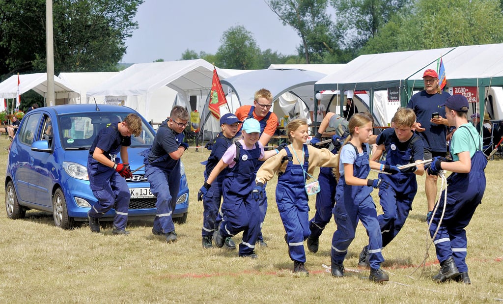 Erfahrungsaustausch und gemeinsame Erlebnisse: Die Kinder- und Jugendfeuerwehr Wethautal zieht an einem Strang und ein Auto vorwärts.