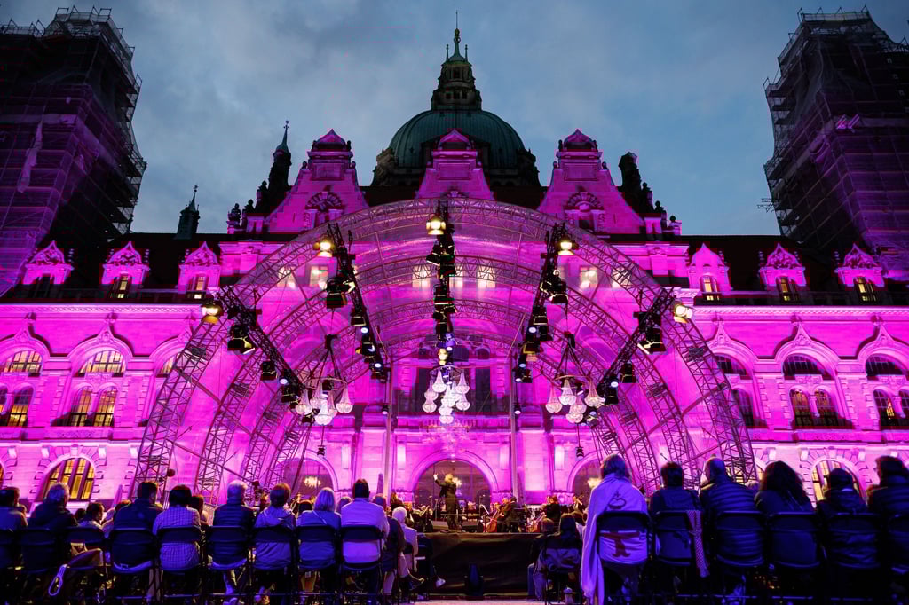 Besucher sitzen vor der Bühne vor dem Neuen Rathaus im Maschpark und schauen sich das Konzert an.