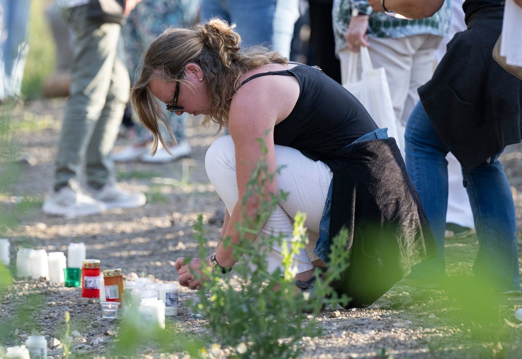 Zum Gedenken an die Opfer der Flutkatastrophe entzünden Menschen am Ufer der Ahr in Schuld Kerzen.