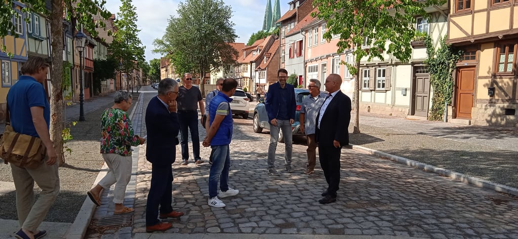 Oberbürgermeister Frank Ruch (r.) und am Bau Beteiligte sehen sich die fertiggestellte Reichenstraße an.