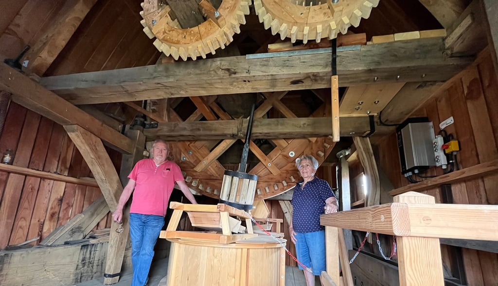 Klaus Wolf und Rita Platte im Inneren der Bockwindmühle. Die Technik aus Holzrädern und Welen muss eigentlich regelmäßig bewegt werden, wegen Schäden an den Flügeln geht das aber schon siet einer Weile nicht.