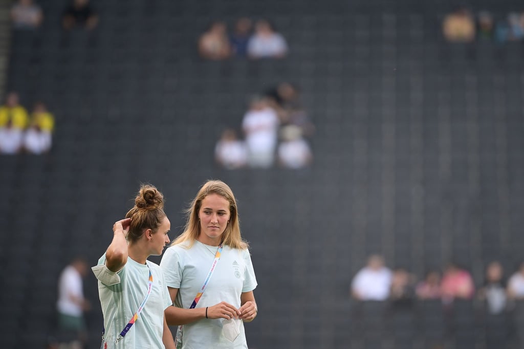 Lina Magull (l) und Sydney Lohmann gehen vor dem Spiel gegen Finnland über das Spielfeld.