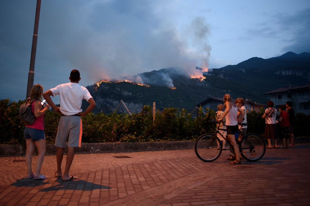 In Italien brennt es vielerorts aufgrund der Trockenheit: Einheimische beobachten, wie das Feuer am zweiten Tag der Brände in Nago (Südtirol) die Vegetation vernichtet.
