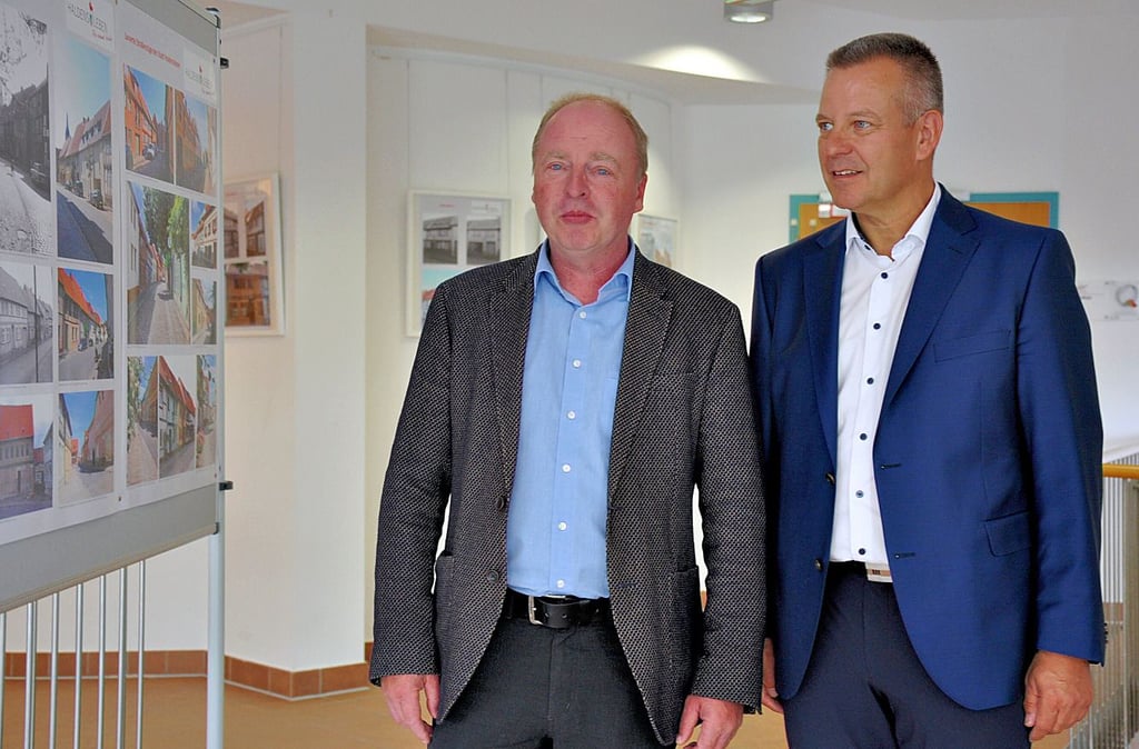 Bauamtsleiter Holger Waldmann (l.) und Bürgermeister Bernhard Hieber (SPD) schauen sich Ausstellungseröffnung „30 Jahre Stadtsanierung“ in der Kulturfabrik in Haldensleben an.