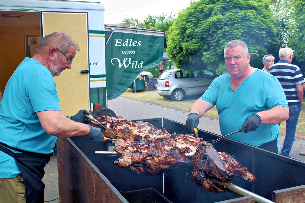 Mario Venker (r.) verkauft „Edles vom Wild“ - hier am Schweinespieß beim Streetfood-Festival zum Roßdorfer Brühtrogpaddeln.