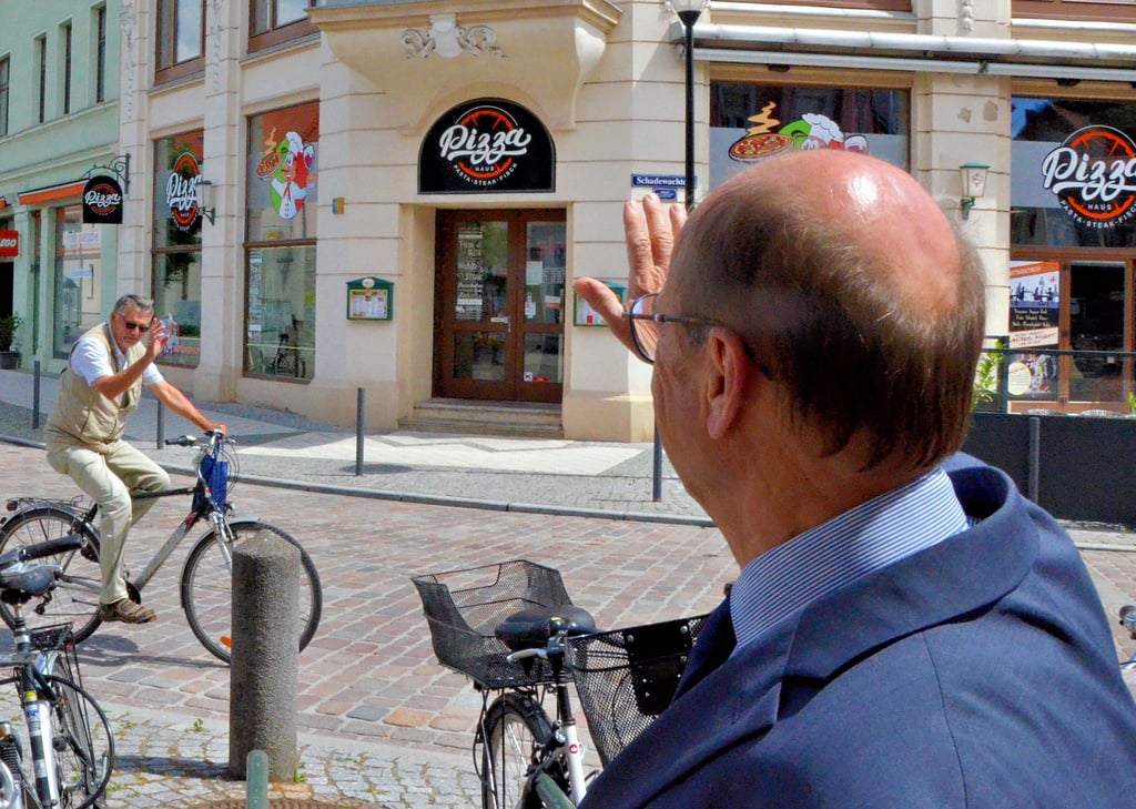Immer freundlich und höflich: Oberbürgermeister Klaus Schmotz winkt einem Radfahrer zu, der ihn grüßt und alles Gute für seinen Lebensabschnitt als Pensionär wünscht, hier ist es Dieter Bergmeier aus der Hansestadt Stendal.