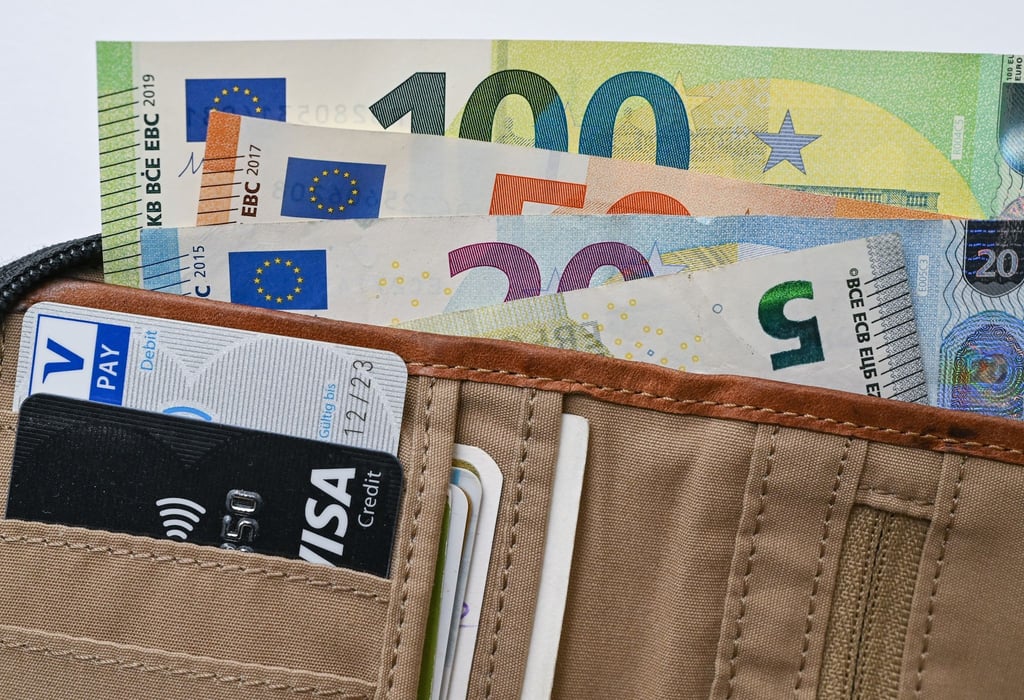 Geldscheine und Bankkarten stecken in einem Portemonnaie.