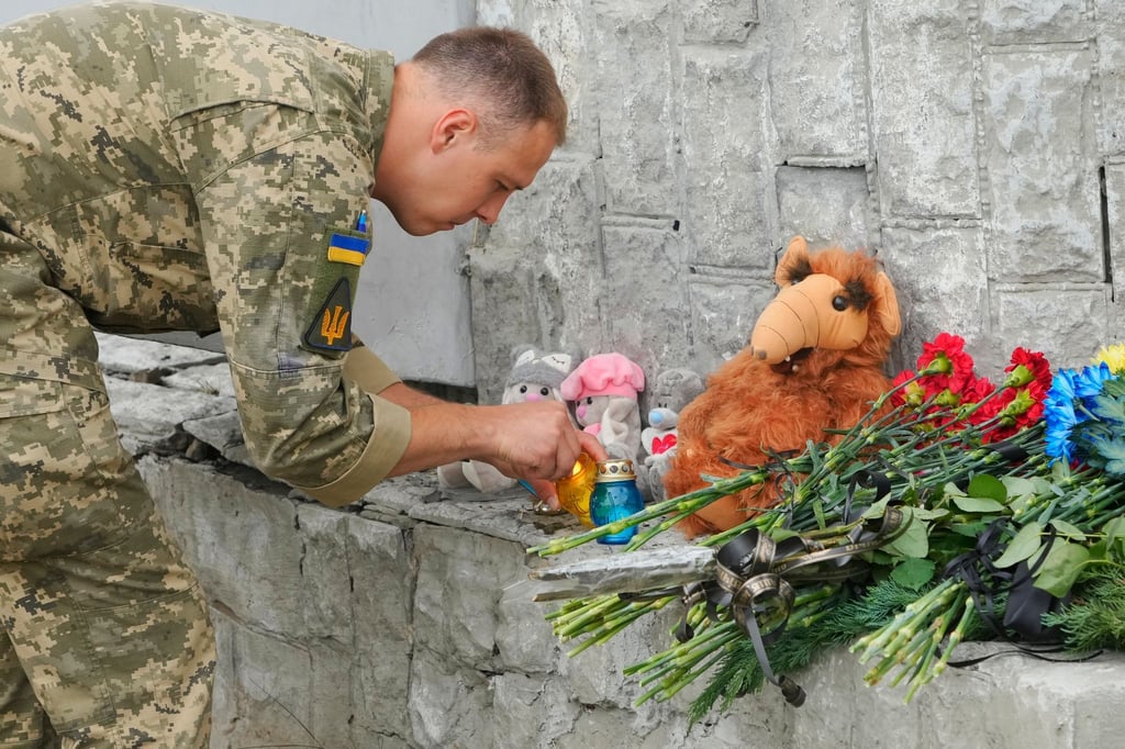 Ein ukrainischer Soldat zündet in Winnyzja eine Kerze für die Opfer russischen Beschusses an. Bei einem Raketenangriff wurden dort mehrere Menschen getötet und weitere verletzt.