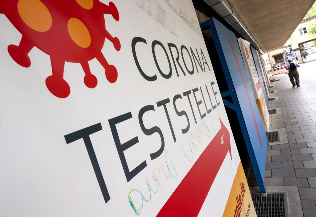 Ein Mann geht an einer Corona-Teststelle in München entlang.