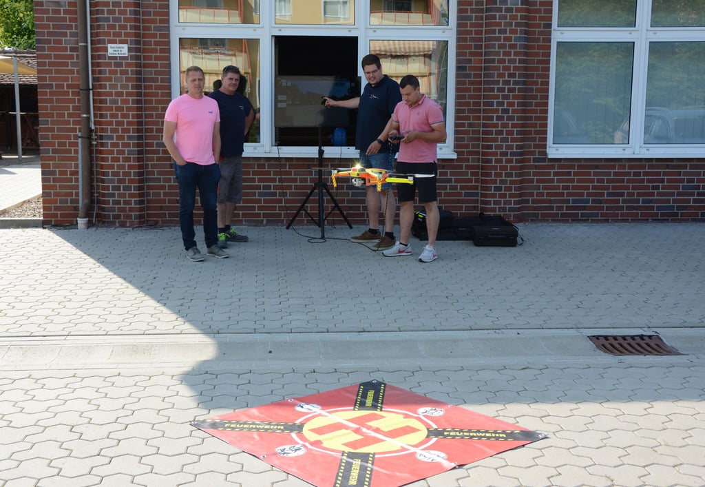Mit Hilfe eines Bildschirmes unterwies Malte Preisker von „Drohne 112“ in einer Gruppe Patrick Lühr (rechts) sowie Björn Schünemann (von links/Ordnungsamt) und Stadtwehrleiter Enrico Schmidt an der neuen und als solche auch erkennbaren Feuerwehrdrohne.