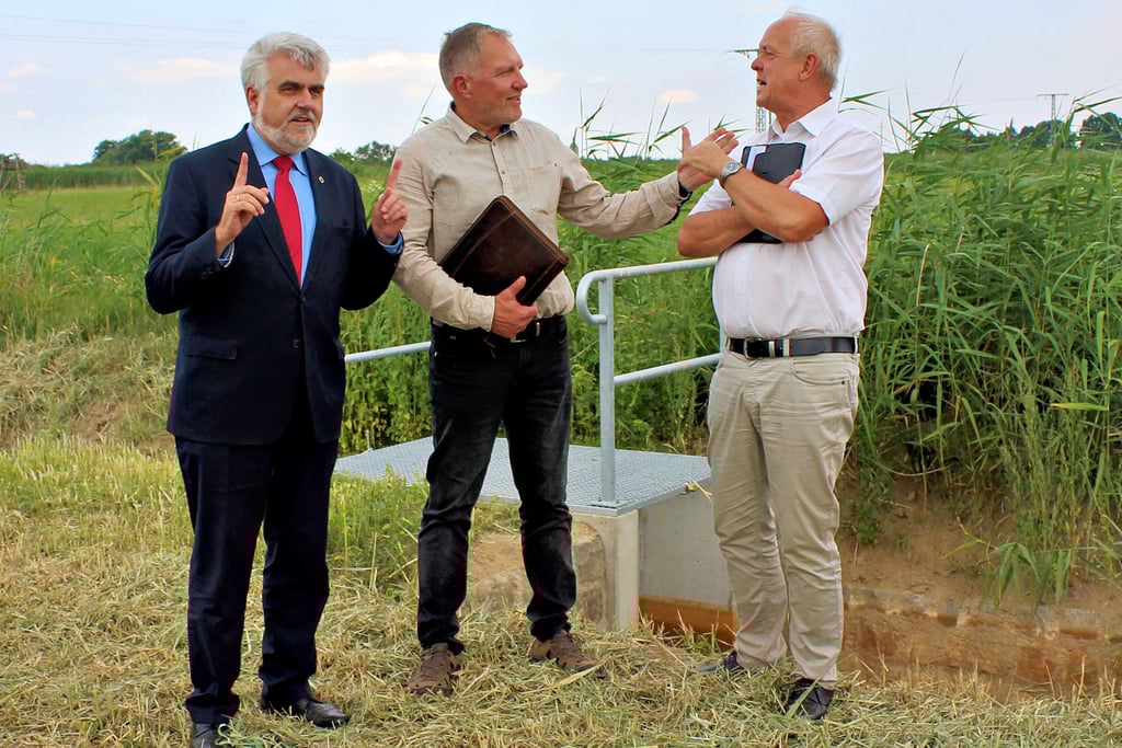 Von links: Umweltminister Armin Willingmann vor der neuen Stauanlage im Gespräch mit UHV-Geschäftsführer Jan Klein und Burkhard Henning, Chef des Landesbetriebes für Hochwasserschutz.