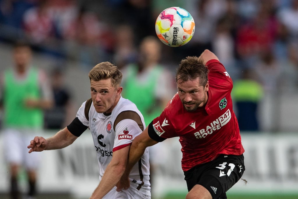 Julian Börner (r) von Hannover 96 im Kampf um den Ball gegen St. Paulis Johannes Eggestein.