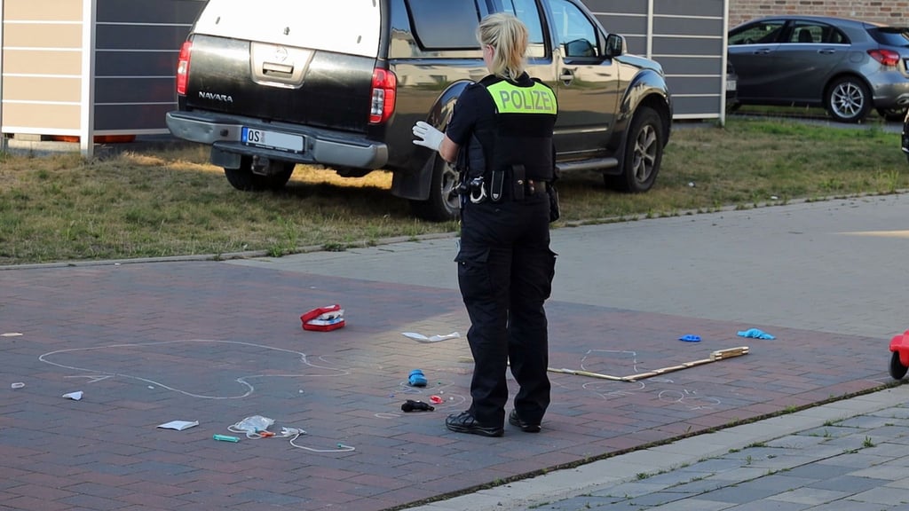 Eine Polizistin sichert Spuren an einer Straße.