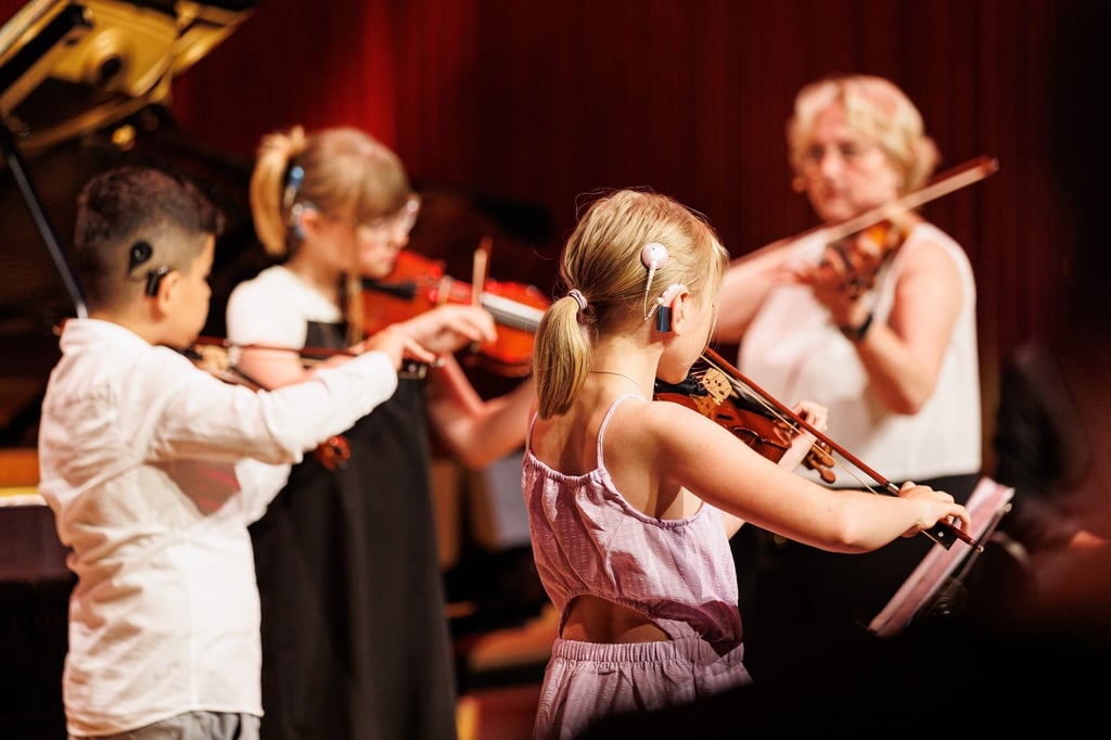 Hörgeschädigte Kinder mit einem Chochlea-Implantat spielen ein Konzert auf Violinen im kleinen Sendesaal vom NDR Landesfunkhaus.