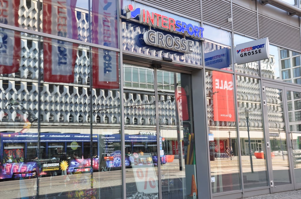 Handel in der Innenstadt in Magdeburg am Breiten Weg: In der Fensterfront von Intersport Grosse im Mariette-Quartier spiegelt sich die markante Fassade von Galeria, dem ehemaligen Karstadt.