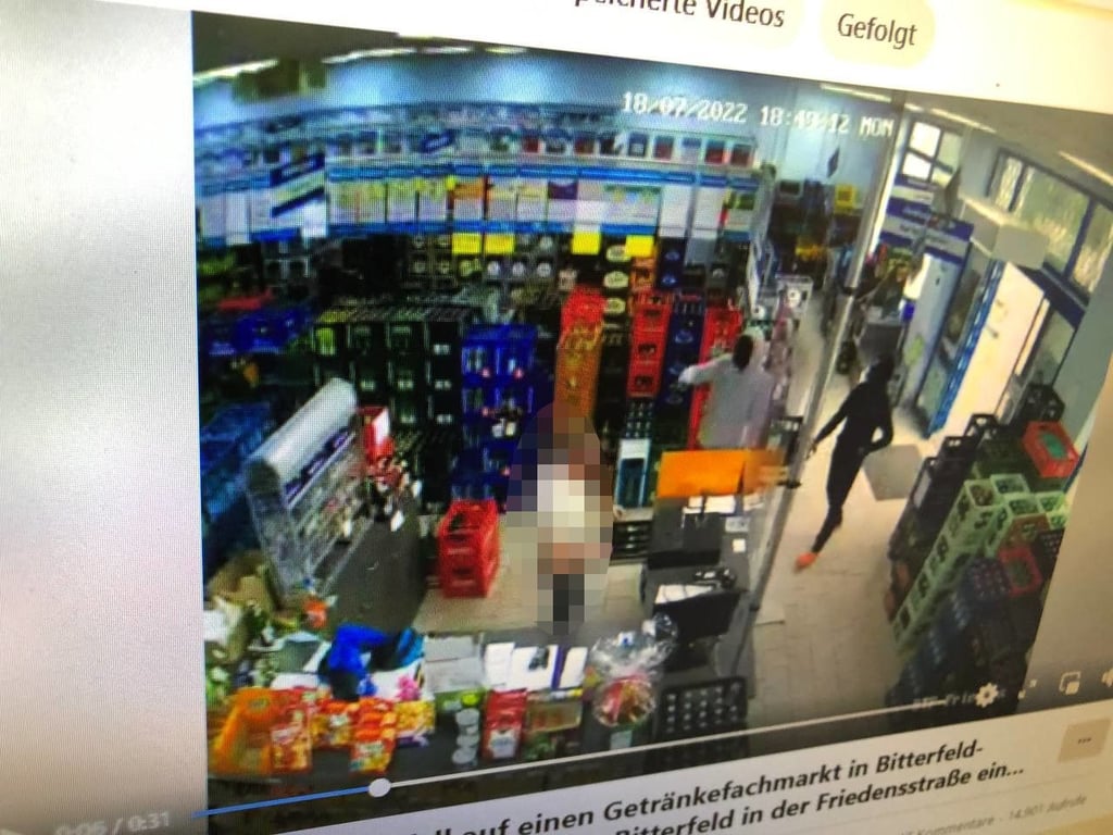 Das Video soll den Überfall auf einen Getränkemarkt in Bitterfeld zeigen. Der Verkäufer steht hinter der Kasse, die beiden Täter bedrohen ihn.