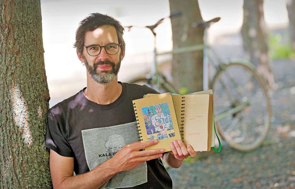 Autor Stefan Thoben hält in seinen Kladden alles fest, was für das Buch wichtig wird. Im Hintergrund ist sein zweites Arbeitsgerät, das Rennrad.
