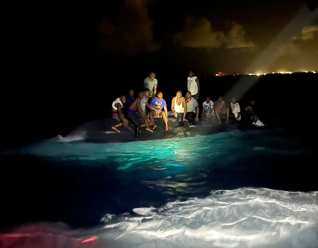 Überlebende sitzen vor ihrer Rettung auf dem gekenterten Boot.