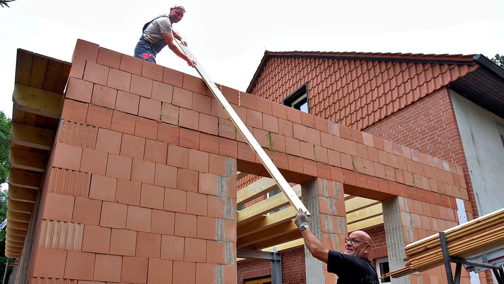 Armin Neumann (unten) von der Vahldorfer Dachdeckermeisterei Claßen reicht seinem Kollegen Thomas Kluge das Holz zum Bau des Flachdaches nach oben. Der Anbau des Calvörder Waldhotels soll noch in diesem Jahr fertig werden.