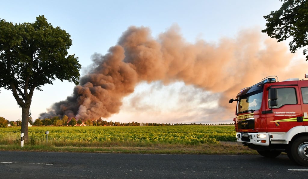 Eine große Rauchwolke steigt in den Himmel bei einem Brand von mehreren Lagerhallen im Peiner Stadtteil Stederdorf.