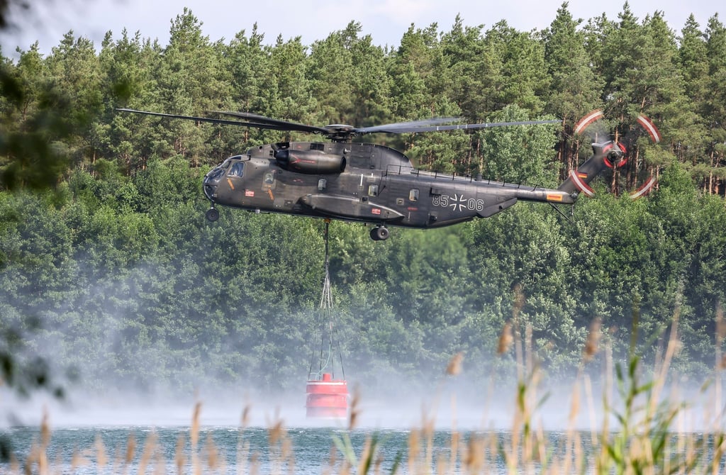 Ein Bundeswehrhubschrauber holt Löschwasser zur Waldbrandbekämpfung.