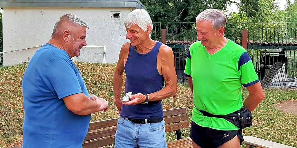 Egbert Zabel von der Läufergruppe des CFC Germania Köthen (M.) spricht mit dem Vereinsvorsitzenden Ronald Maaß (l.) und Georg Grohmann (r.).