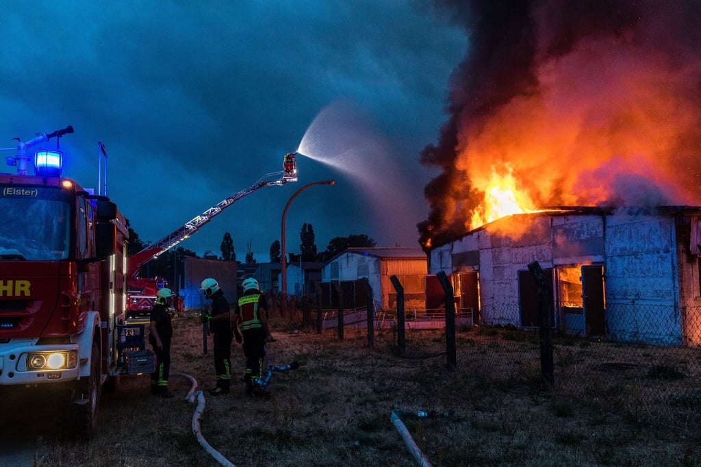 Einsatzkräfte der Feuerwehr versuchen, einen Gebäudebrand in der Region Falkenberg /Elster zu löschen.
