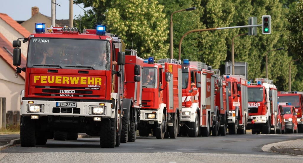 Zahlreiche Einsatzkräfte der Feuewehr kommen in einem Konvoi zu einem Waldbrand.