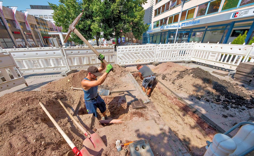 Aufbau eines Trinkbrunnens am Platz der Deutschen Einheit: Mirko Oecknick und Tobias Pannicke (mit Hacke) der Firma TUG Oranienbaum schachten den Wasseranschluß für den Brunnen aus.