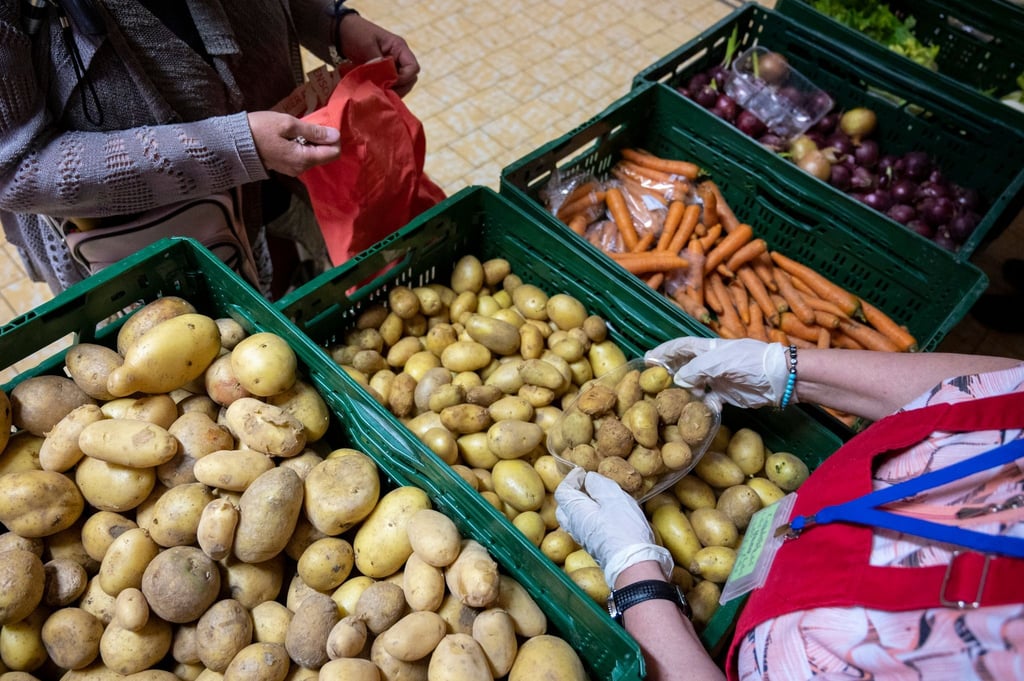 In der Laib und Seele- Ausgabestelle verteilt eine ehrenamtliche Mitarbeiterin Kartoffeln.