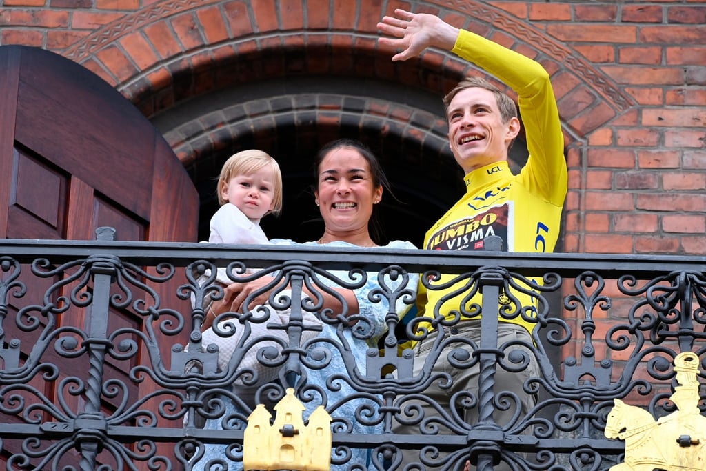 Tour-Sieger Jonas Vingegaard steht mit seiner Freundin Trine und seiner Tochter Frida auf dem Rathausbalkon in Kopenhagen.