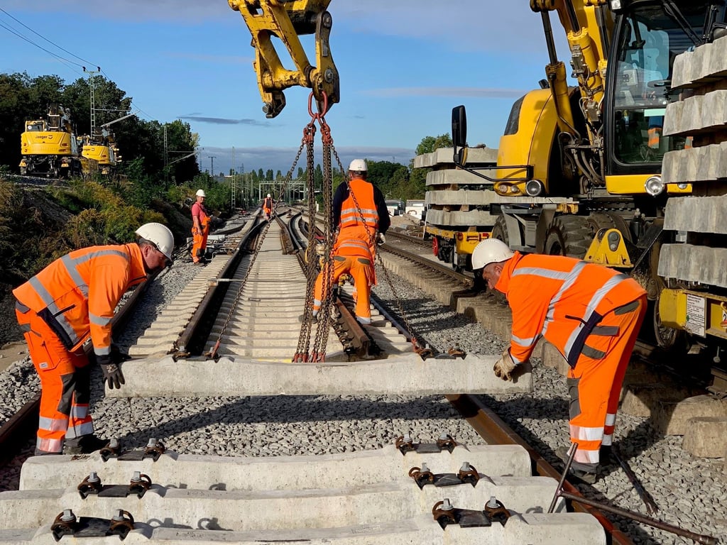 Arbeiter verlegen Betonschwellen. Ein bestimmter Bautyp steht im Verdacht, das Zugunglück Anfang Juni in Bayern mitverursacht zu haben. Nun werden solche Schwellen auch in Sachsen-Anhalt ausgetauscht, was im Harz für Chaos sorgt.
