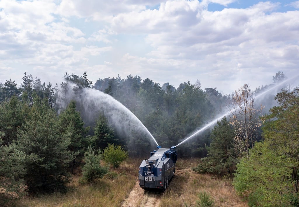 Ein Wasserwerfer der Brandenburger Polizei bekämpft einen Waldbrand.