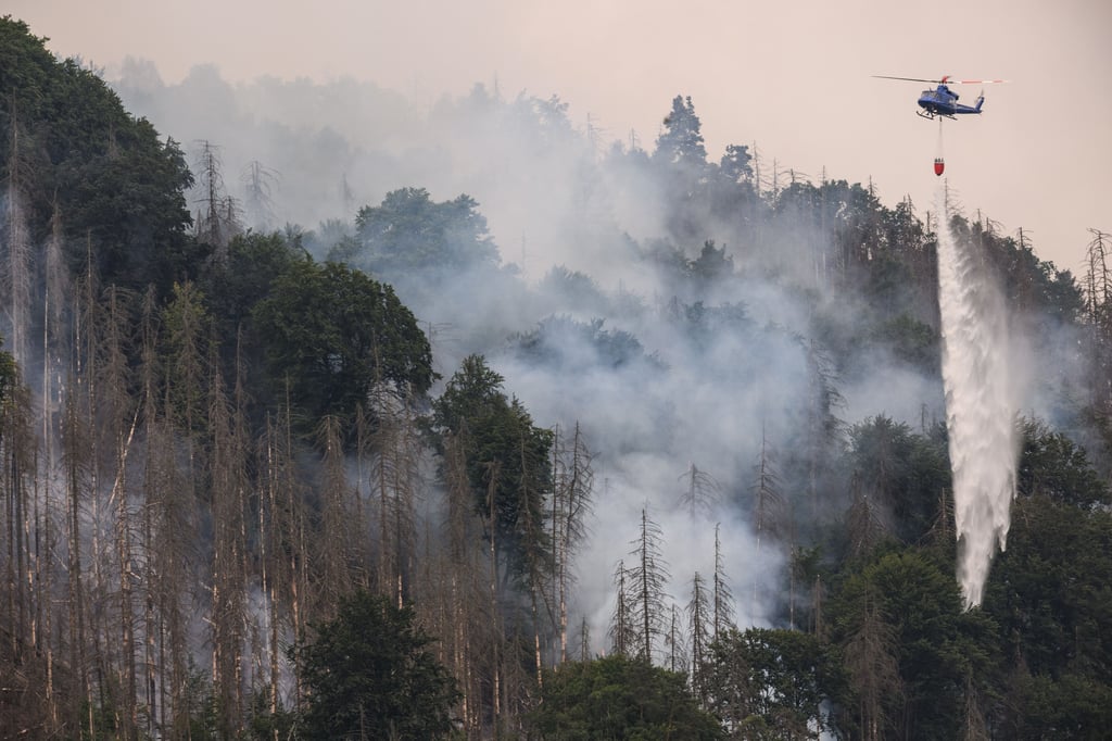 Mit einem Hubschrauber wird ein Waldbrand im tschechischen Nationalpark Böhmische Schweiz in Hrensko nahe der Grenze zu Sachsen gelöscht.