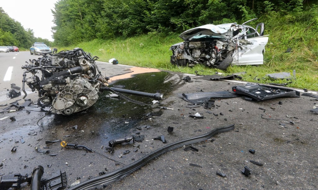 Ein demoliertes Auto steht nach einer Kollision mit einem LKW neben der B312. Durch den Aufprall wurde der Motorblock herausgerissen. .