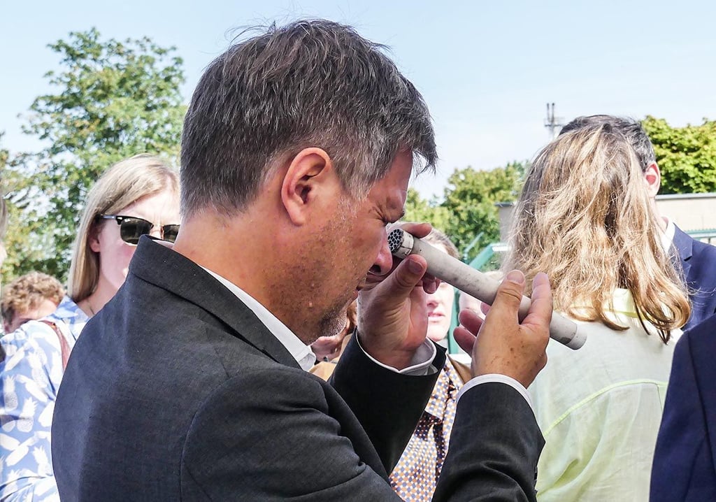 Wirtschaftsminister Robert Habeck betrachtet in Bad Lauchstädt in Sachsen-Anhalt eine Membran zur Reinigung des Wasserstoffs.