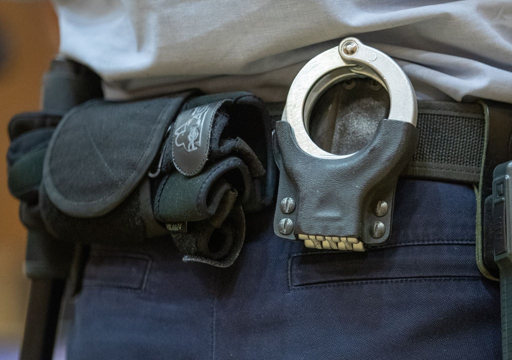 Handschellen stecken in der Gürtelhalterung eines Justizbeamten.
