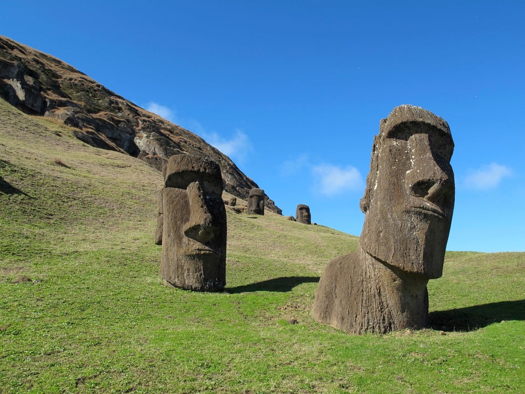 Ikonisches Motiv: In Stein geschlagene Köpfe, „Moais“, stehen auf einem Feld auf der Osterinsel.